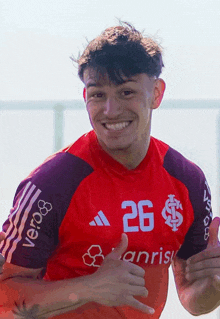 a young man wearing a red shirt that says 26 on it