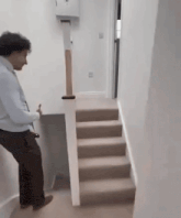 a man is standing on a set of stairs in a hallway .