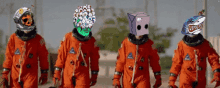 a group of astronauts are walking in a line with one wearing a shark mask