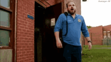 a man in a blue shirt stands in front of a brick building with a sign that says monday on it