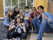 a group of people are posing for a picture and one of them is wearing a shirt with the letter w on it