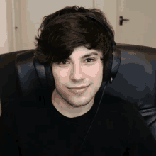 a young man is wearing headphones and sitting in a chair .