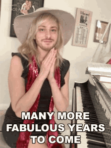 a man with a beard is sitting in front of a piano with the words many more fabulous years to come