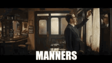 a man in a suit and tie is standing in front of a window with the word manners on the bottom