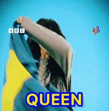 a woman is holding a flag and the word queen is on the screen