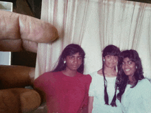 three young women are posing for a picture and one of them is wearing earrings