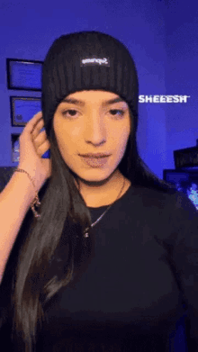 a woman wearing a black beanie says sheeesh on the bottom