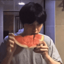 a man is eating a slice of watermelon with a knife