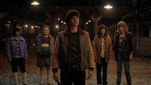 a group of people are standing in a barn looking up