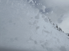 a large pile of snow is falling on a mountain