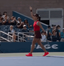 a woman walking on a tennis court with a sign that says ace