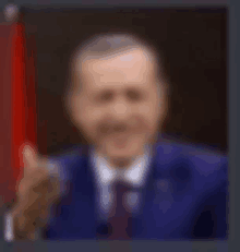 a blurry picture of a man in a suit and tie giving a thumbs up sign .