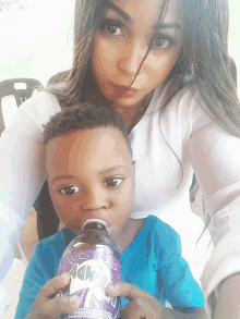 a little boy drinking from a purple bottle that says ' dr. pepper ' on it