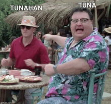 a man in a hawaiian shirt is sitting at a table with other people .