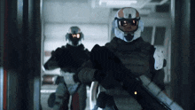 two soldiers are walking in a hallway and one has a helmet that says ' sd ' on it