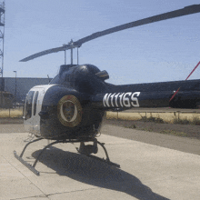 a black and white helicopter with the number n11165 on the tail