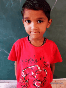 a young boy wears a red shirt that says looking at the city