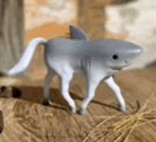 a toy shark with a long tail is sitting on a table .