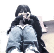 a person making a heart shape with their hands while sitting down