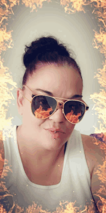 a woman wearing sunglasses with a fire reflection