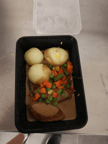 a tray of food with potatoes carrots green beans and peas