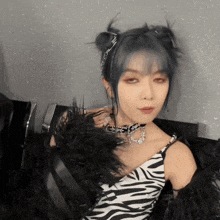a woman with blue hair is wearing a zebra print dress and feathers