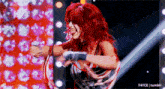 a woman with red hair is standing in a ring with her tongue out .
