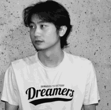 a man wearing a white shirt that says dreamers