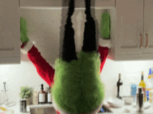 a person in a santa costume is upside down in a kitchen