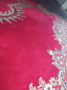 a close up of a red rug with a floral design