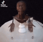 a statue of a man 's head and hands are sitting on a white table .