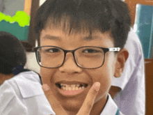 a young boy wearing glasses is making a face