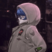 a person wearing a hoodie with a mask on their face .