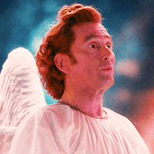 a man with red hair and angel wings is wearing a white shirt