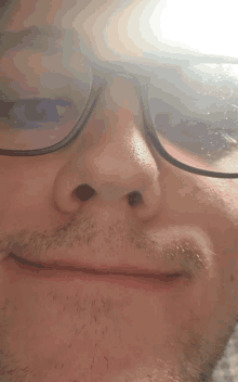 a close up of a man 's nose with glasses on