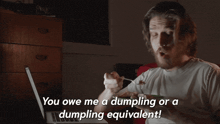 a man sitting in front of a laptop with the words " you owe me a dumpling or a dumpling equivalent " above him