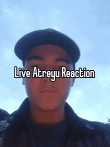 a man wearing a hat with the words live atreyu reaction written above him