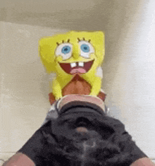 a spongebob statue is sitting on a person 's feet .