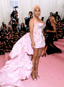 a woman in a pink dress is standing on a pink floor