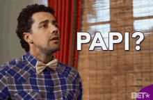 a man in a plaid shirt and bow tie is asking " papi "