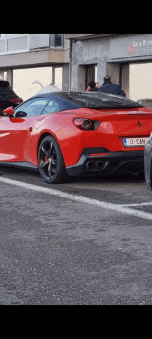 a red ferrari is parked in a parking lot