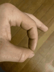 a close up of a person 's hand with their thumb extended