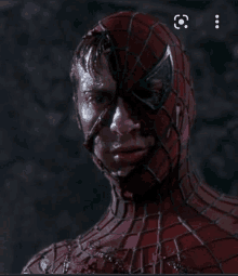 a close up of a man in a spiderman costume with blood on his face