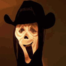 a scream mask is wearing a metallica hat and sticking out its tongue .