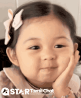 a little girl is smiling with her hand on her chin and a star tamil chat logo is behind her