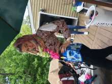 a woman wearing a scarf is standing on a deck with a laundry basket