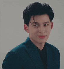 a young man wearing a blue suit is making a fist