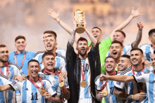 a group of soccer players holding up a trophy with the number 10 on the front