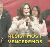 a woman speaking into a microphone with the words " resistimos y venceremos " below her