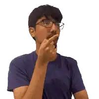 a man wearing glasses and a blue shirt is pointing his finger
